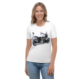 Puede incluir: Camiseta blanca con un diseño de motocicleta. La motocicleta está representada en blanco y negro con detalles cromados. La camiseta tiene cuello redondo y mangas cortas.