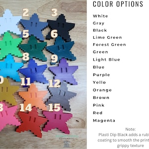 K&ouml;nnte beinhalten: Eine Tabelle mit 15 verschiedenen Farboptionen f&uuml;r ein 3D-gedrucktes sternf&ouml;rmiges Objekt. Die Farben umfassen Wei&szlig;, Grau, Schwarz, Limettengr&uuml;n, Waldgr&uuml;n, Gr&uuml;n, Hellblau, Blau, Lila, Gelb, Orange, Braun, Rosa, Rot und Magenta. Die Tabelle enth&auml;lt auch einen Hinweis, dass Plasti Dip Black eine gummierte Beschichtung hinzuf&uuml;gt, um den Druck zu gl&auml;tten und eine griffige Textur zu erzeugen.