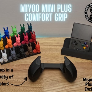 Puede incluir: Una empuñadura negra impresa en 3D para un dispositivo de juego portátil. La empuñadura tiene forma de dos manos, con un esquema de color negro y blanco. El texto "MIYOO MINI PLUS COMFORT GRIP" se muestra encima de la empuñadura. El texto "Comes in a variety of colors" se muestra debajo de la empuñadura. El texto "Miyoo Mini Plus Not Included" se muestra debajo de la empuñadura.