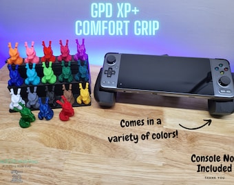 May include: A 3D printed grip for the GPD XP+ handheld gaming console. The grip is available in a variety of colors. The text "GPD XP+ COMFORT GRIP" is displayed at the top of the image. The text "Comes in a variety of colors!" is displayed below the grip. The text "Console Not Included" is displayed in the lower right corner of the image.
