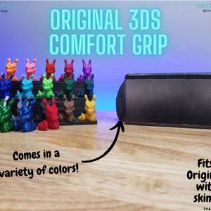 Op de afbeelding: Een 3D-geprinte grip voor de originele Nintendo 3DS handheld-gameconsole. De grip is verkrijgbaar in verschillende kleuren en is ontworpen om te passen op de console zonder een skin of case. De afbeelding toont een verzameling van de grips in verschillende kleuren, samen met een zwarte 3DS-console.