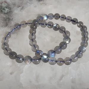 May include: Two labradorite gemstone bracelets with iridescent blue and grey beads.