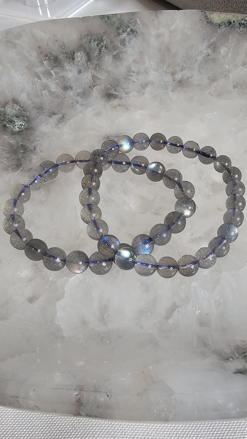 May include: Two labradorite gemstone bracelets with iridescent blue and grey beads.