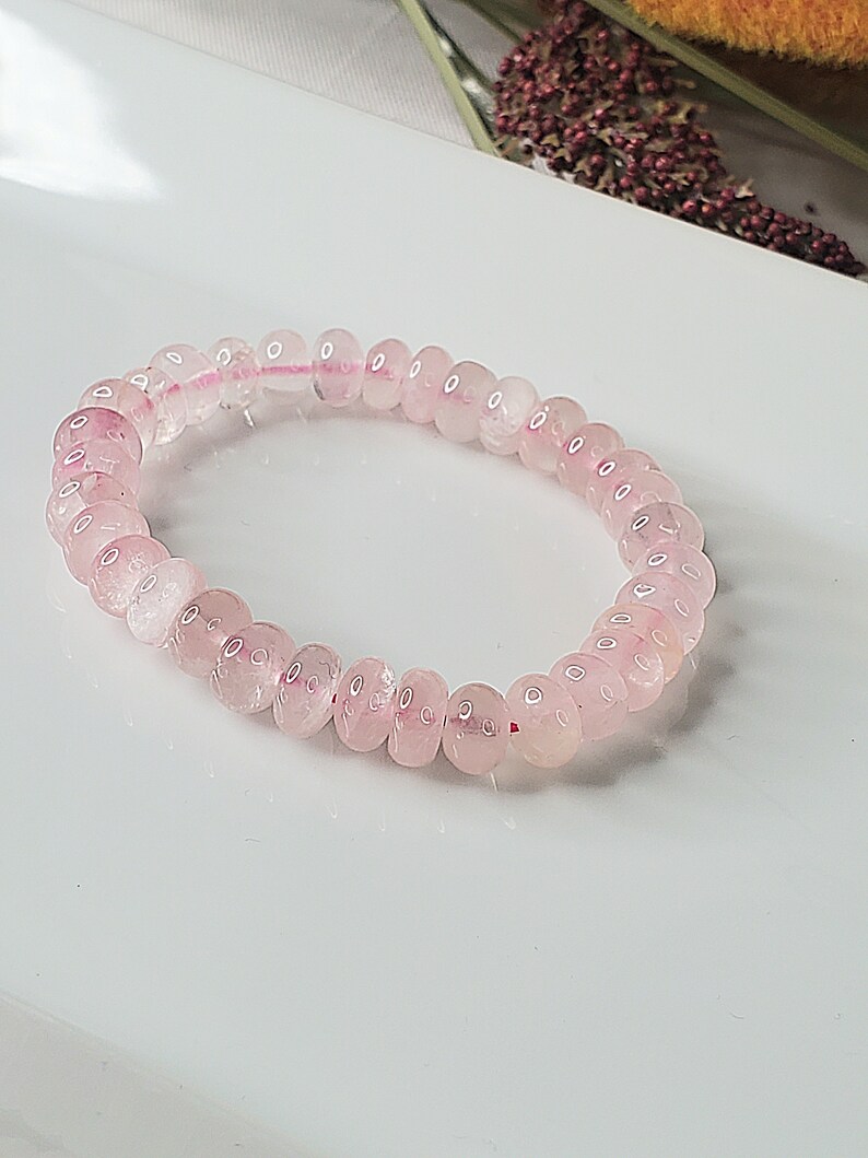 May include: A pink rose quartz beaded bracelet with a stretchy elastic band.