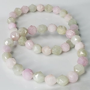 May include: Two bracelets made of faceted gemstone beads. The beads are a mix of light green and pink.