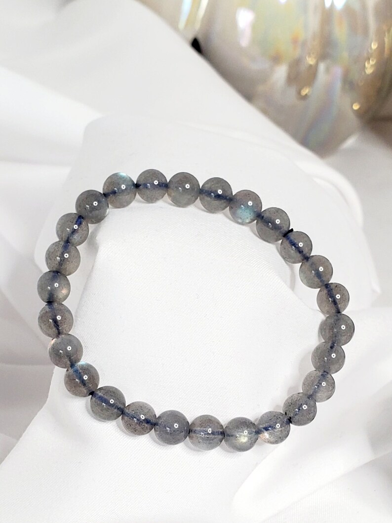 May include: A gray labradorite gemstone bracelet with round beads.