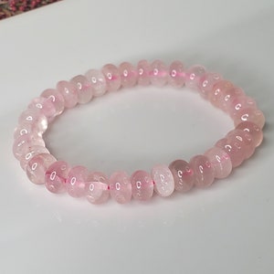May include: A pink rose quartz beaded bracelet with a stretchy elastic band.