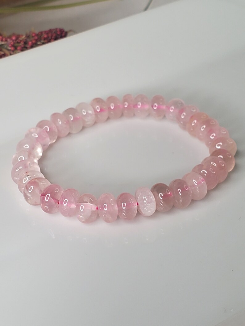 May include: A pink rose quartz beaded bracelet with a stretchy elastic band.