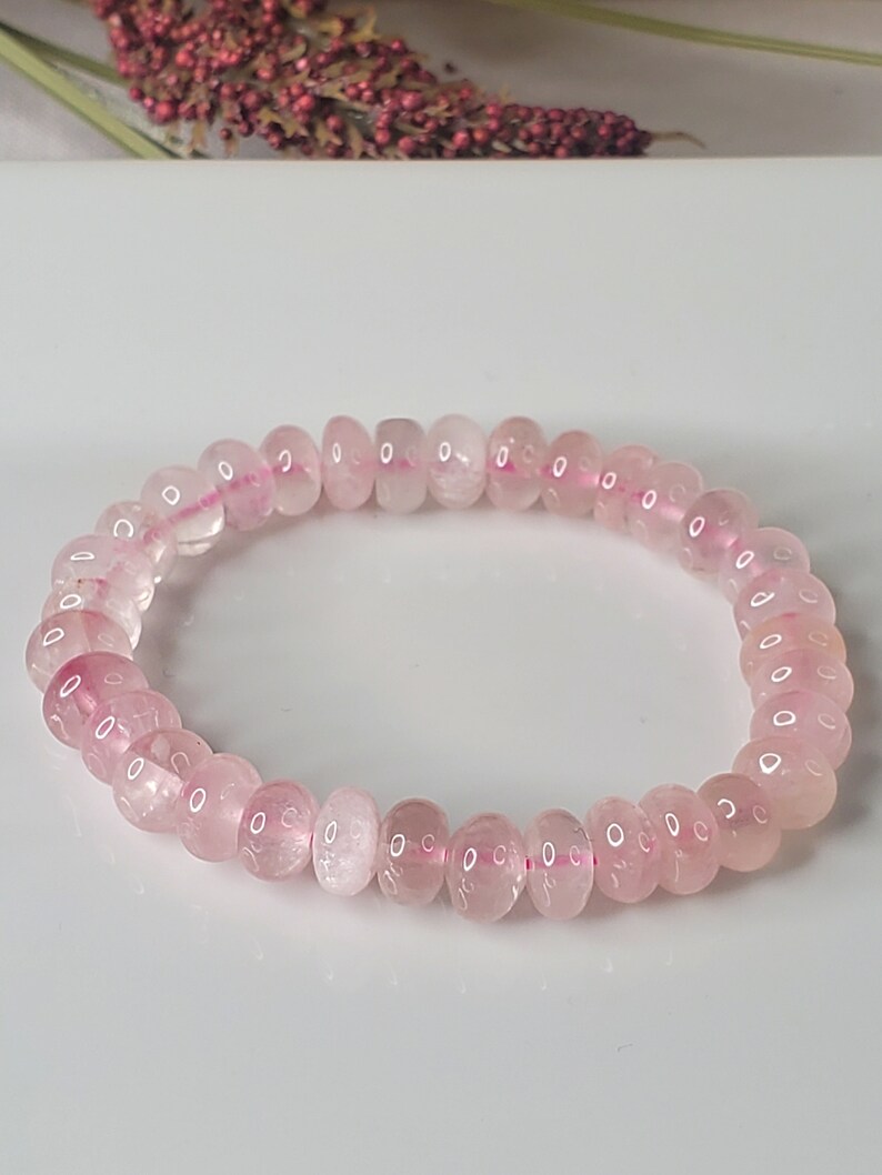May include: A pink rose quartz beaded bracelet with a stretchy elastic band.