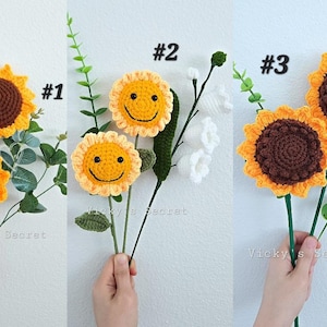 Op de afbeelding: Drie gehaakte zonnebloemboeketten met verschillende gezichtsuitdrukkingen. Het eerste boeket heeft twee zonnebloemen met bruine centra, het tweede boeket heeft twee zonnebloemen met gele centra en glimlachende gezichten, en het derde boeket heeft twee zonnebloemen met bruine centra.