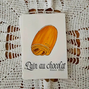 Carte postale : Baguette | Croissant | Chocolatine | Croissant | Crêpe | Macaron | Café | Chouquette | Croque-Monsieur Pain au chocolat
