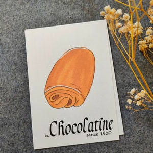 Carte postale : Baguette | Croissant | Chocolatine | Croissant | Crêpe | Macaron | Café | Chouquette | Croque-Monsieur Chocolatine