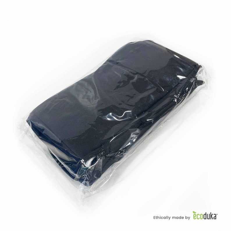 May include: A black, rectangular item, possibly a case or pouch, is sealed within clear plastic packaging. The item is folded and appears to be made of a dark fabric. The packaging is transparent, allowing a clear view of the product.