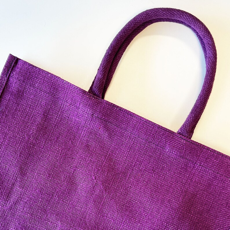 May include: A purple tote bag made of woven fabric with thick purple fabric handles.
