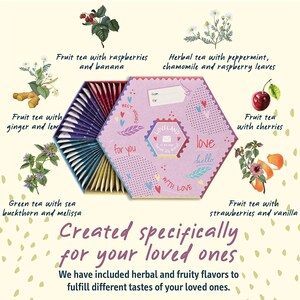 K&ouml;nnte beinhalten: Eine sechseckige Schachtel mit Teebeuteln in rosa und lila. Die Schachtel tr&auml;gt die Aufschrift "Loveland" und "With Love". Die Teebeutel sind in einem Kreis um die Schachtel angeordnet. Die Teebeutel sind mit verschiedenen Geschmacksrichtungen gekennzeichnet, darunter Fr&uuml;chtetee mit Himbeeren und Banane, Kr&auml;utertee mit Pfefferminze, Kamille und Himbeerbl&auml;ttern, Fr&uuml;chtetee mit Kirschen, Fr&uuml;chtetee mit Erdbeeren und Vanille sowie gr&uuml;ner Tee mit Sanddorn und Melisse.