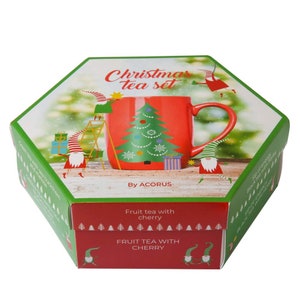 May include: A red and green Christmas tea set with a mug featuring a Christmas tree design. The box has a green background with a festive design and the text "Christmas tea set" and "By ACORUS". The box also includes the text "Fruit tea with cherry" and "FRUIT TEA WITH CHERRY".