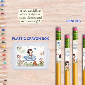 Pu&ograve; includere: Una collezione di matite colorate e un portapenne in plastica trasparente con un tema di Biancaneve. Le matite hanno gomme rosa e maniche decorative. Il portapenne presenta il testo "Sarah's Crayons".