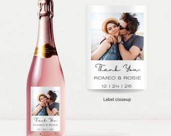 May include: A pink champagne bottle with a gold foil label and a photo label. The photo label says "Thank You" and features a couple. The text "WINE BOTTLE LABELS" is at the top.
