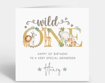 May include: A white card with a gold "wild one" graphic featuring a lion, zebra, giraffe, elephant, and a monkey. The card has the text "Happy 1st Birthday to a very special grandson Henry" in black.