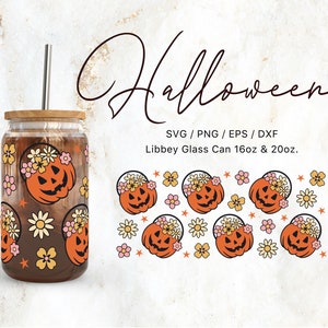 Op de afbeelding: Een helder glazen Libbey-kan met een bamboe deksel en een roestvrijstalen rietje. Het glas is versierd met een herhalend patroon van oranje pompoenen met bloemenkransen en bloemen. Het woord "Halloween" is in een script geschreven.