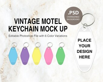 May include: Six different colour variations of a vintage motel keychain mockup. The keychain is a white oval with the text "PLACE YOUR DESIGN HERE". The mockup is editable in Photoshop.
