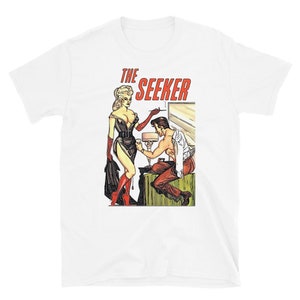 May include: A white t-shirt with a vintage comic book cover illustration of a woman in a black dress and a man in a white shirt. The text "THE SEEKER" is printed in red on the shirt.