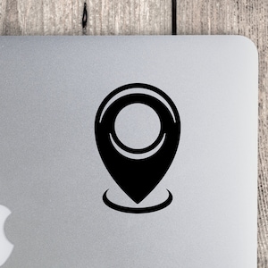 May include: A black location pin icon with a circle around it, on a silver laptop.
