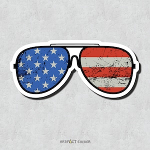 May include: A sticker of a pair of aviator sunglasses with the American flag design. The left lens has the stars and the right lens has the stripes. The sticker has a distressed look.
