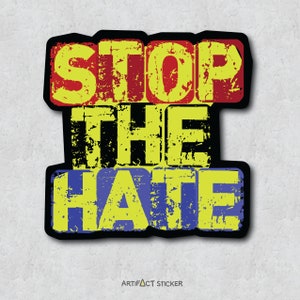 May include: A yellow, red, and blue sticker with the words "Stop the Hate" in a distressed font.