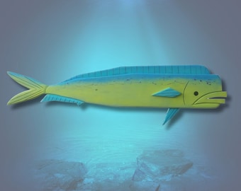 May include: A wooden carving of a yellow and blue mahi-mahi fish, also known as a dolphin fish, with a textured surface. The fish is swimming in a blue and green water background.
