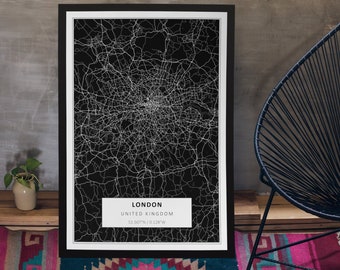 May include: Black and white map print of London, United Kingdom with the city name and coordinates, "LONDON, UNITED KINGDOM, 51.507N / 0.128W", printed at the bottom. The map is framed in a black frame with a white mat.