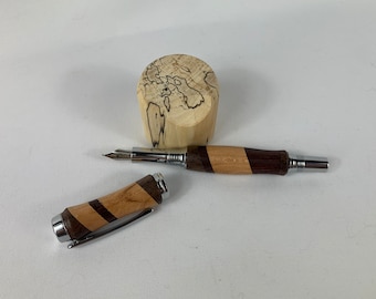 Pluma estilográfica torneada a mano en madera exótica, con segmentos de palisandro, cerezo y nogal.