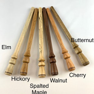 Peut inclure: Gros plan sur sept chevilles en bois avec différents motifs de grain de bois. Les chevilles sont étiquetées avec leurs types de bois : orme, hickory, érable moucheté, noyer, cerisier et noyer.