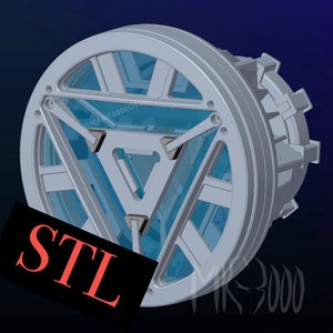 Puede incluir: Un modelo impreso en 3D del reactor de arco de Iron Man, un dispositivo circular con un centro translúcido azul y un marco metálico plateado. El modelo está etiquetado como "STL" en texto rojo.