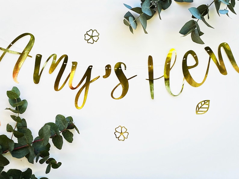 May include: Gold foil banner with the text "Amy's 16" with green eucalyptus leaves and gold foil flowers.
