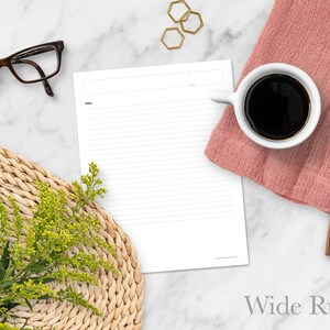 May include: A white sheet of paper with wide ruled lines. The paper is on a marble surface with a cup of coffee, a wooden spoon, a woven placemat, a sprig of yellow flowers, and gold hexagonal shapes.
