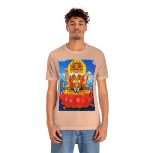 May include: A light peach t-shirt with a colorful image of a four-faced Hindu deity sitting on a lotus flower.