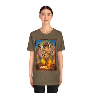 May include: A heather grey t-shirt with a colorful image of the Hindu deity Ganesha. The image is framed in a brown border and features Ganesha sitting on a throne with a book in his lap.