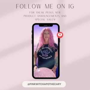 May include: A smartphone displays a woman with pink hair wearing a black t-shirt with the text "LET ME CONSULT MY CRYSTALS." The image is framed by text that reads "FOLLOW ME ON IG" and "@PINKWITCHAPOTHECARY."