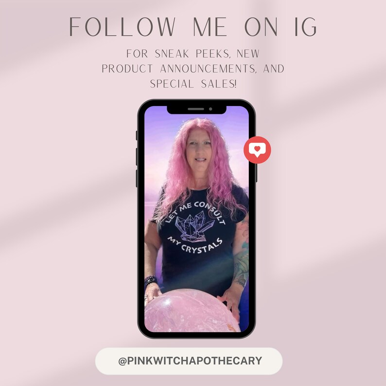 May include: A smartphone displays a woman with pink hair wearing a black t-shirt with the text "LET ME CONSULT MY CRYSTALS." The image is framed by text that reads "FOLLOW ME ON IG" and "@PINKWITCHAPOTHECARY."