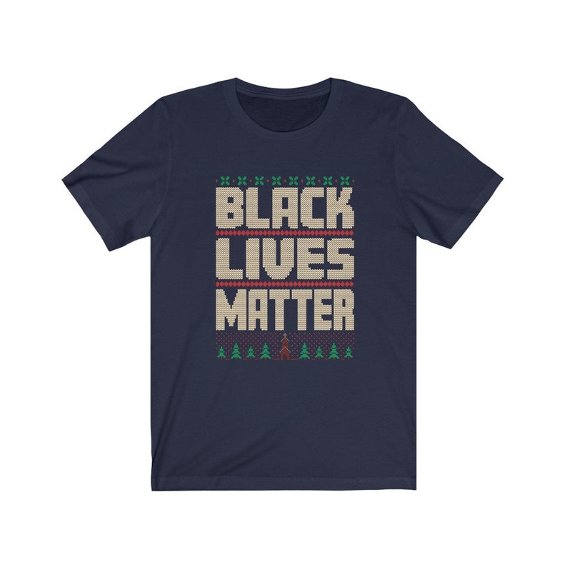 May include: Navy blue t-shirt with a white knit pattern that reads "Black Lives Matter". The pattern includes small green trees and a red figure.
