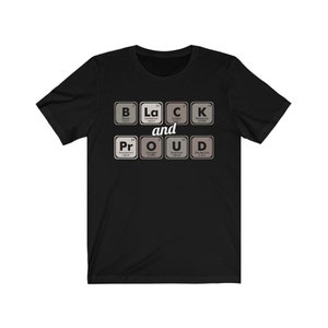 May include: Black t-shirt with the words "BLACK and PROUD" spelled out using periodic table elements. The design features the elements Boron, Lanthanum, Carbon, Potassium, Praseodymium, Oxygen, Uranium, and Deuterium.