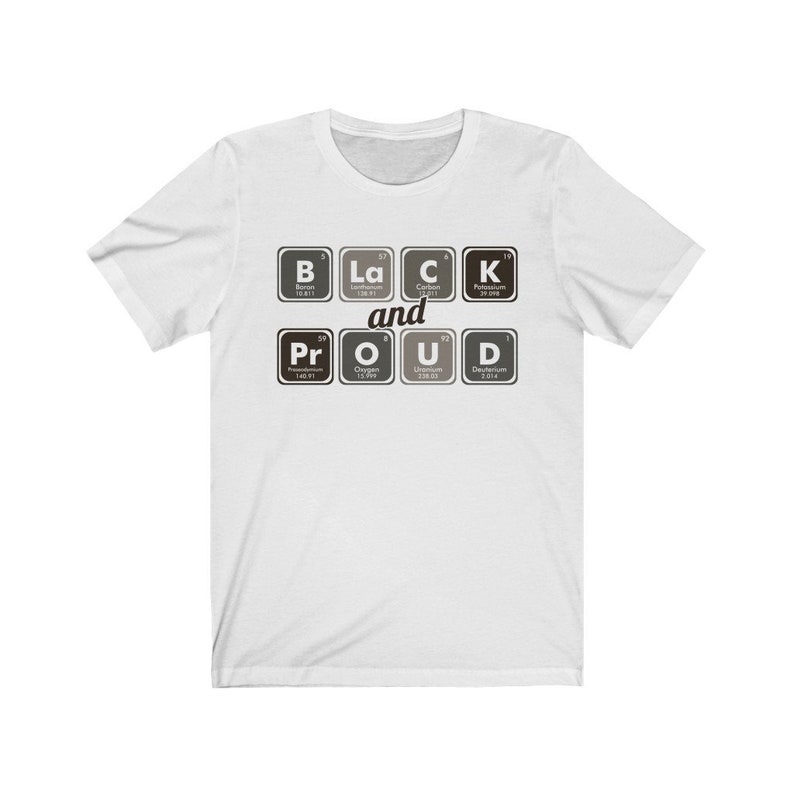 May include: White t-shirt with the words "BLACK and PROUD" spelled out using periodic table elements. The design features the elements B, La, C, K, Pr, O, U, and D in a black and white color scheme.
