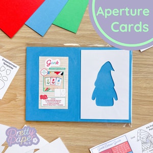 Puede incluir: Un paquete de aperturas de tarjetas azul con un diseño de gnomo. El paquete incluye 4 aperturas rectangulares, 4 aperturas cuadradas, 3 sobres blancos C5 y plantillas de patrón de plegado Gonk.