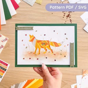May include: A handmade greeting card with a geometric fox design in shades of orange and yellow, set against a watercolor background. The card is framed in green and includes the text "To a lovely friend" and "Have a fantastic day".
