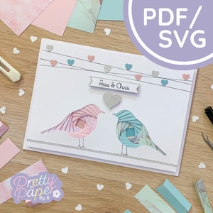 May include: A white card with a pink and blue paper bird design. The card has a banner that says "Jess & Chris" and a string of hearts.