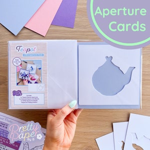 Könnte beinhalten: Ein Teekannen-Karten-Öffnungs-Set mit Anweisungen, wie man Karten wie die gezeigten herstellt. Das Set enthält 3 Teekannen-Quadrat-Öffnungen, 3 farbige quadratische Kartenrohlinge, 3 weiße quadratische Umschläge und ein Teekannen-Faltmuster.