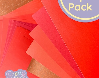 May include: A stack of red cardstock paper in various shades of red. The paper is arranged in a fan shape. The text "Paper Pack" is visible in the upper right corner of the image.