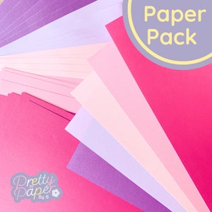 May include: A pack of pink and purple cardstock paper. The paper is arranged in a fan shape. The text "Paper Pack" is written on a purple circle.