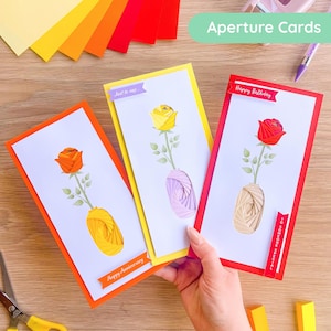 May include: Three handmade greeting cards with rose designs. Each card features a different colored rose: orange, yellow, and red. The cards have decorative vases and the text "Happy Anniversary", "Just to say...", and "Happy Birthday".